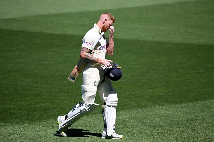 Ben Stokes walks off field with cricket bat under his arm 