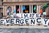 Activists hold a sign reading climate emergency alongside Sydney Lord Mayor Clover Moore.
