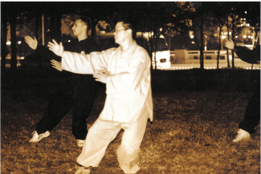 two men are training martial arts in a park