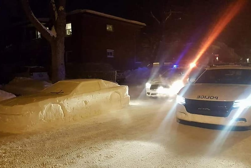 Police in Canada pull up next to a car made out of snow.