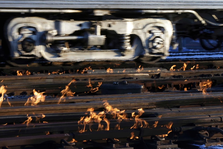 A train heads to downtown Chicago as the gas-fired switch heater on the rails keeps the ice and snow off the switches.