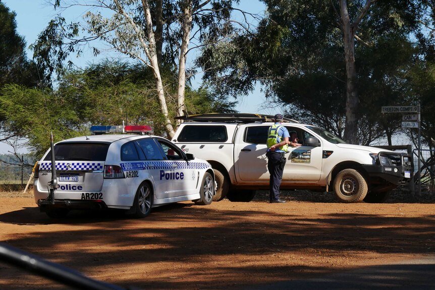 A police officer talks to a person in a car near the site of a murder-suicide near Margaret River.