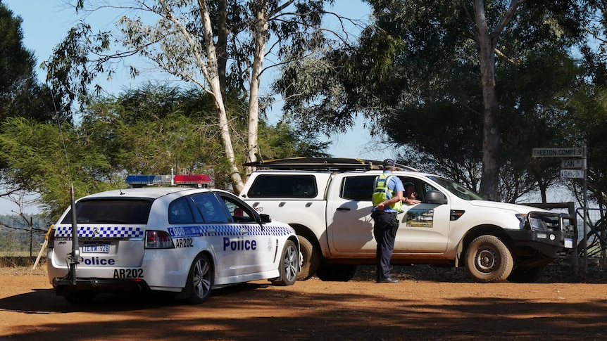 A police officer talks to a person in a car near the site of a murder-suicide near Margaret River.