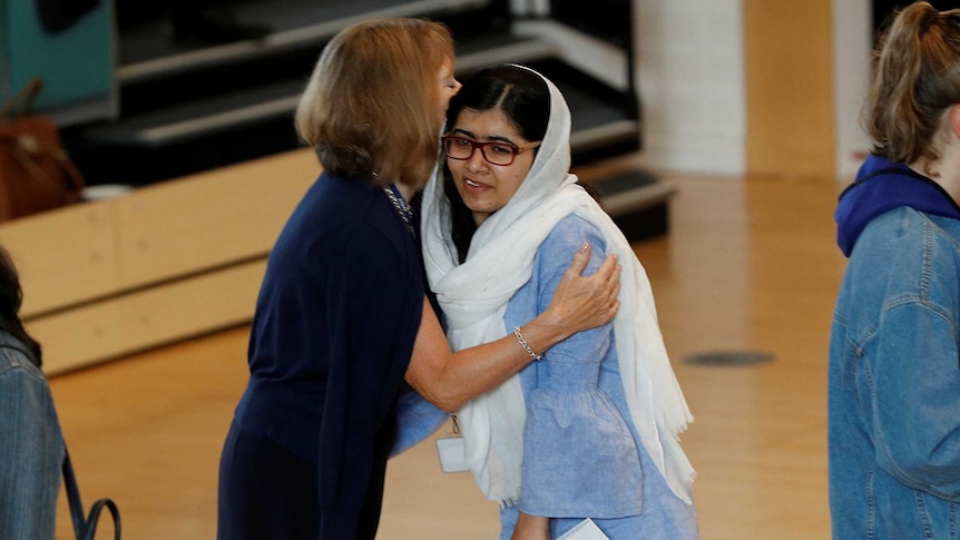 Malala receives a hug after from an older woman
