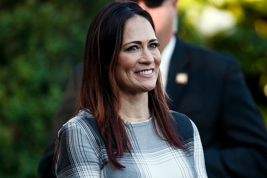 A woman with brunette hair smiles