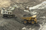 Generic TV still of large yellow mining truck being loaded up with coal from Qld mine