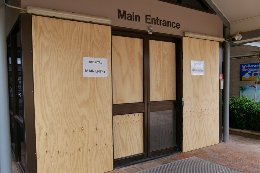 glass windows and doors boarded up after vandalism 