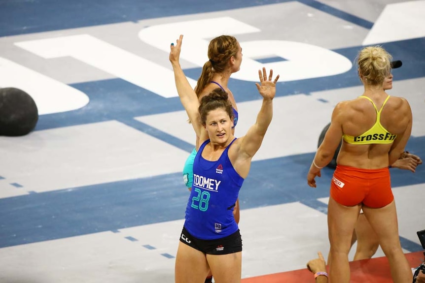 Gladstone athlete Tia-Clair Toomey with arms raised, waving to crowd