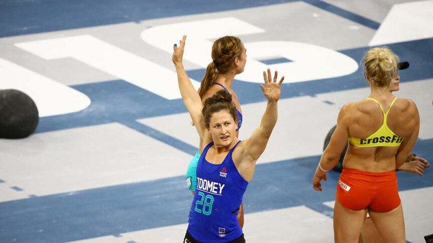Gladstone athlete Tia-Clair Toomey with arms raised, waving to crowd
