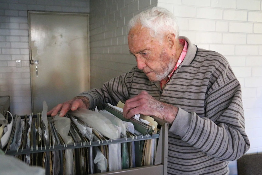 David Goodall looks through documents in a filing cabinet drawer.