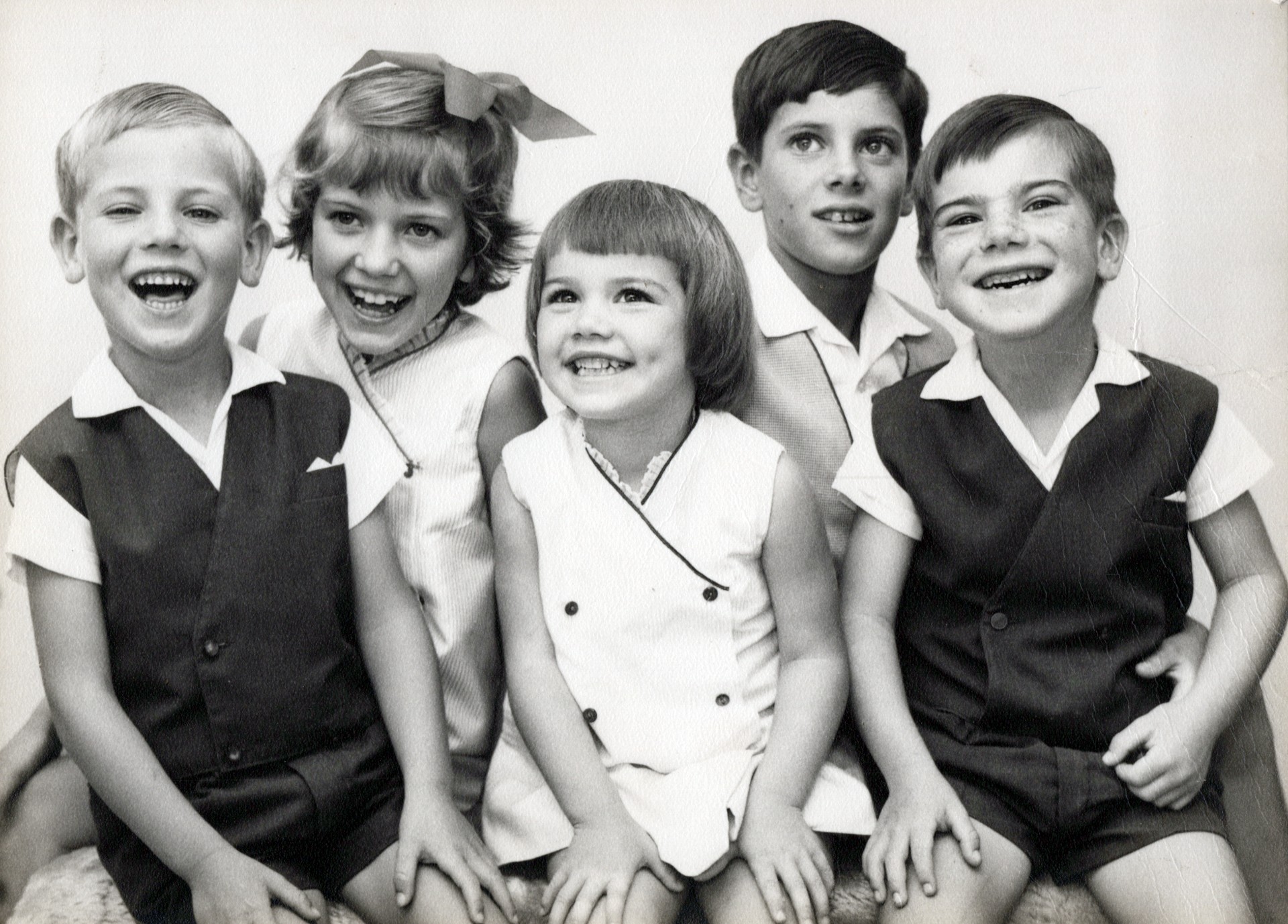 A black and white photo of five young children: two girls and three boys.