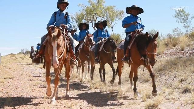 Indigenous children ride horses