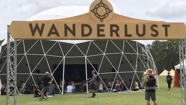 Wanderlust festival sign in front of yoga tent.