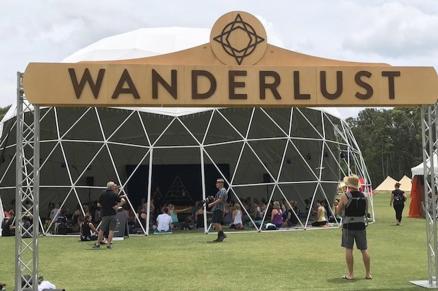 Wanderlust festival sign in front of yoga tent.