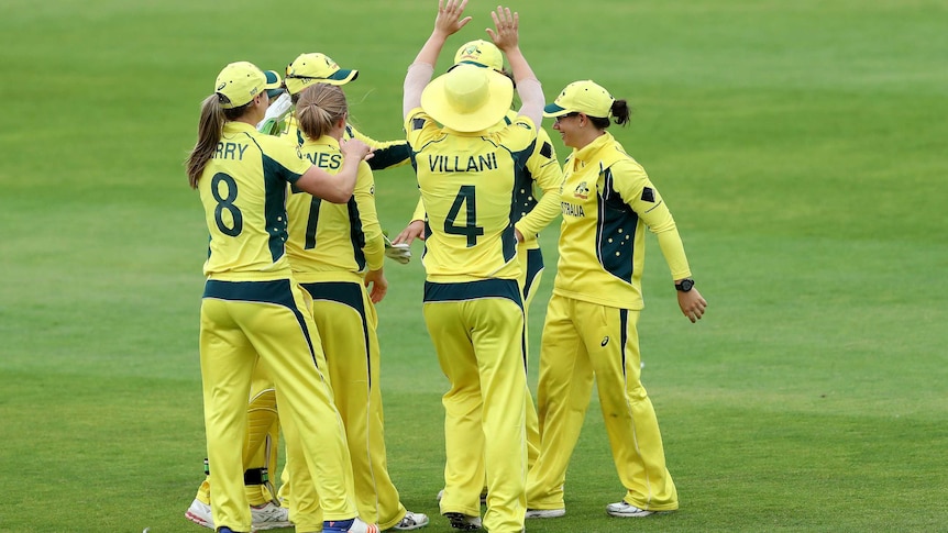 Australian players in a huddle celebrating a South African wicket.