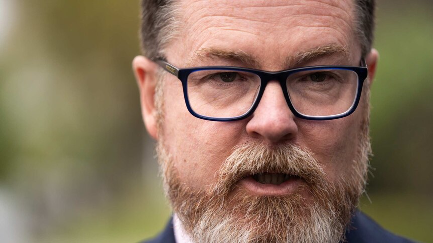 Closeup of a bespectacled, bearded middle-aged man.