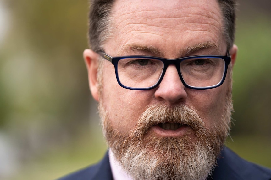 Closeup of a bespectacled, bearded middle-aged man.