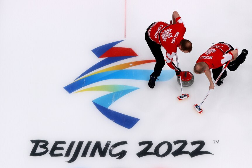 Los canadienses Geoff Walker (L) y Mark Nichols compiten en curling