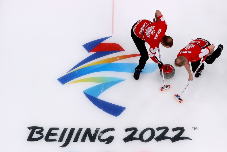 Canadians Geoff Walker (L) and Mark Nichols compete in curling