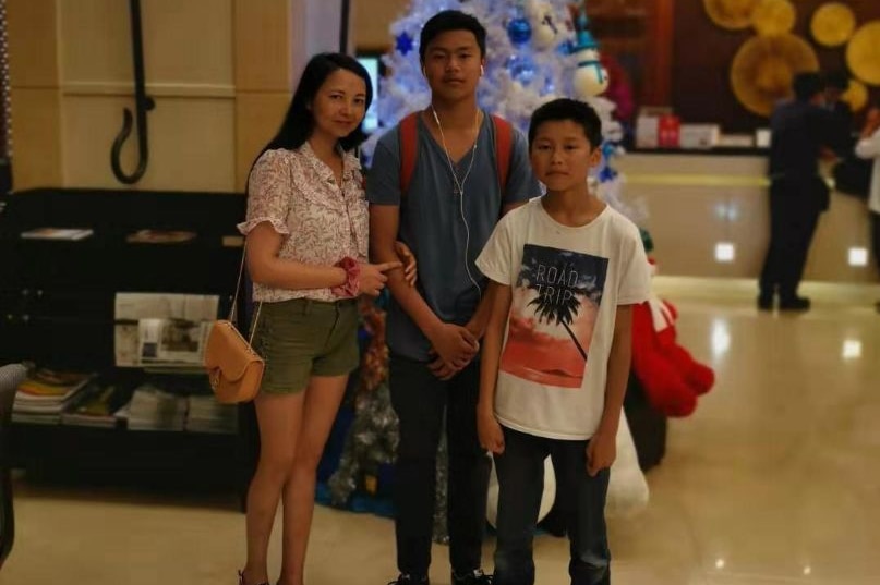 墨尔本妈妈Lily Li与两个儿子在一家商场内，背后有棵圣诞树。