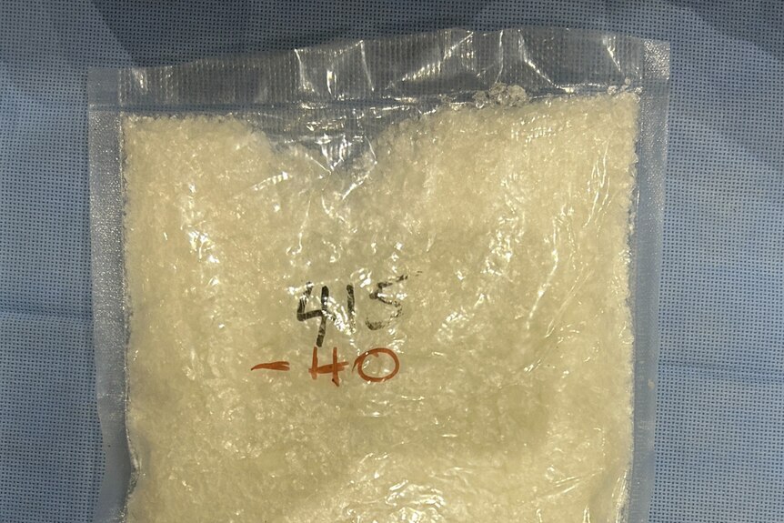 A clear vacuum-sealed bag of sand-coloured powder, with an ACT Policing logo in the bottom right.