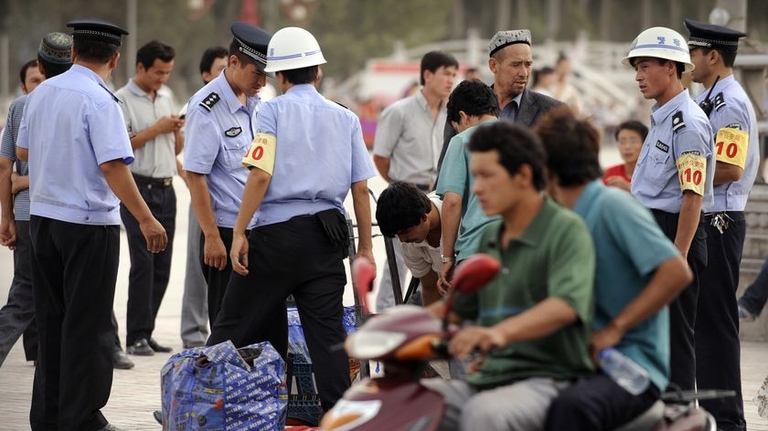 Ethnic Uighurs have their bags searched in the main square in Xinjiang's Kashgar city