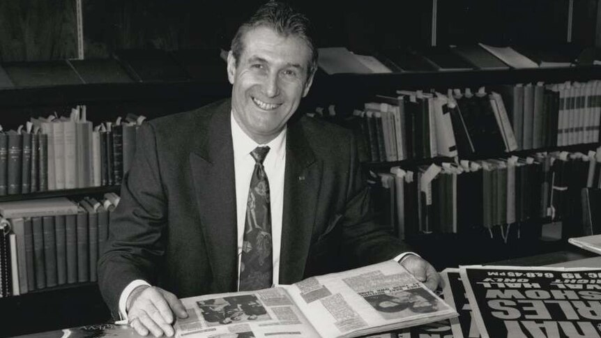 Harry M Miller sits at a desk in 1986.