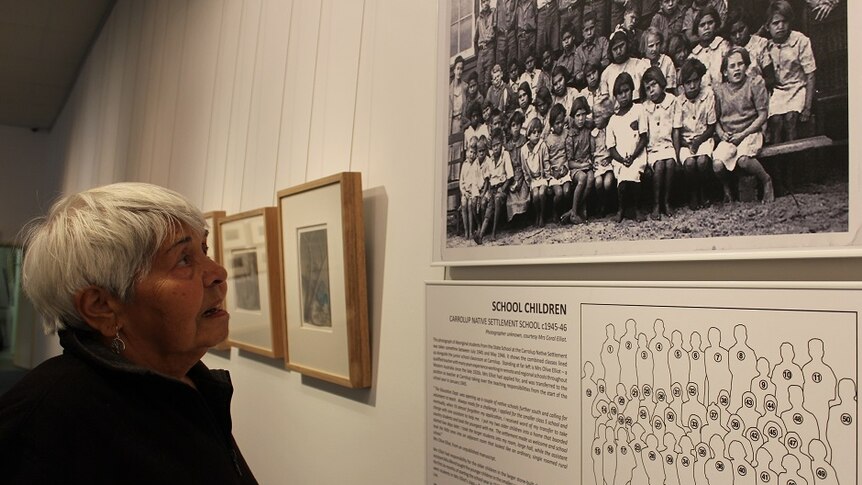 Alma studies a photo of herself as a young girl at the Carrolup Native Settlement School, circa 1945-46.