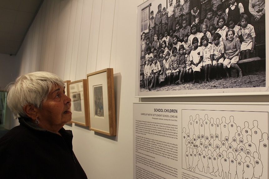 Alma studies a photo of herself as a young girl at the Carrolup Native Settlement School