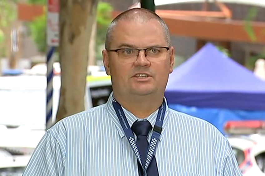 A plain-clothes detective speaking to a media conference