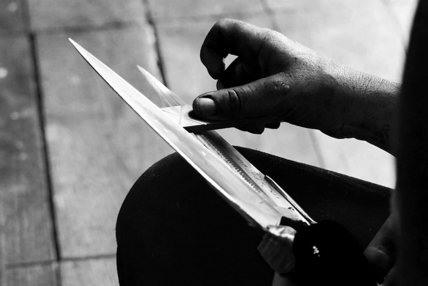 Black-and-white image of shearing blades being sharpened