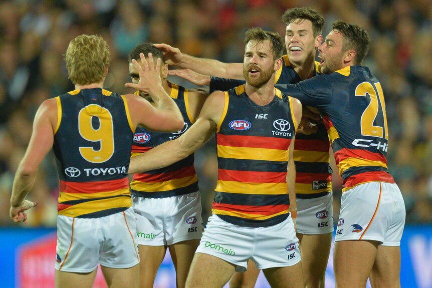 The Crows congratulate each other after kicking a goal against the Power at Adelaide Oval.