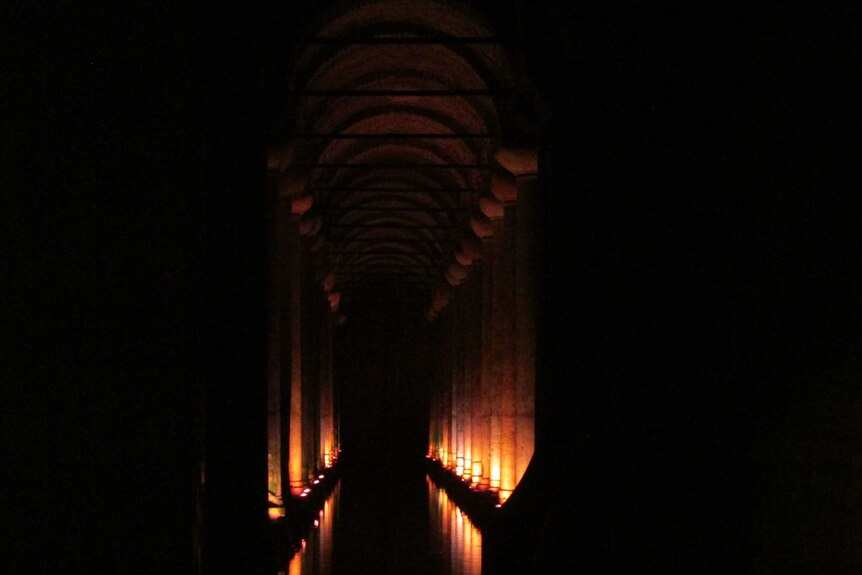 A dark tunnel lit by candles