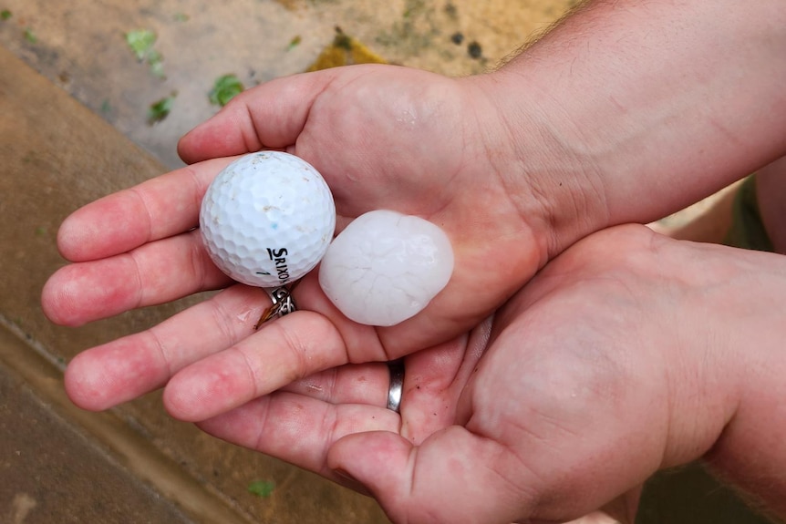 a person holding a golf ball and a hailstone after a hail storm in orange on christmas day 2023