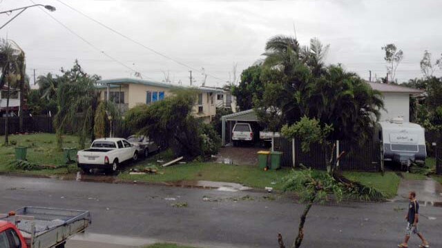 A local walks down a street in Townsville, north Queensland, after a 'mini-tornado'