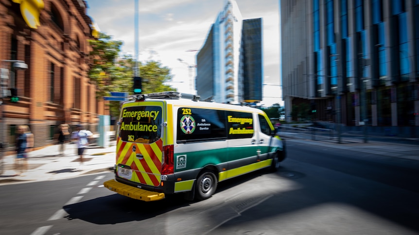 An ambulance vehicle turns a corner on a CBD road
