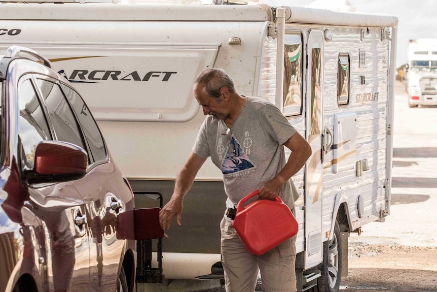 A man filling up his car with petrol.