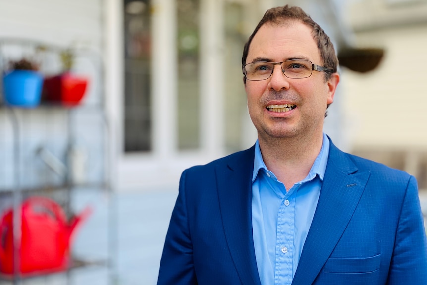 Economist Terry Rawnsley stands outside his house in Melbourne.