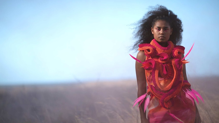 A young indigenous model wears a contemporary looking dress made using traditional indigenous weaving practices
