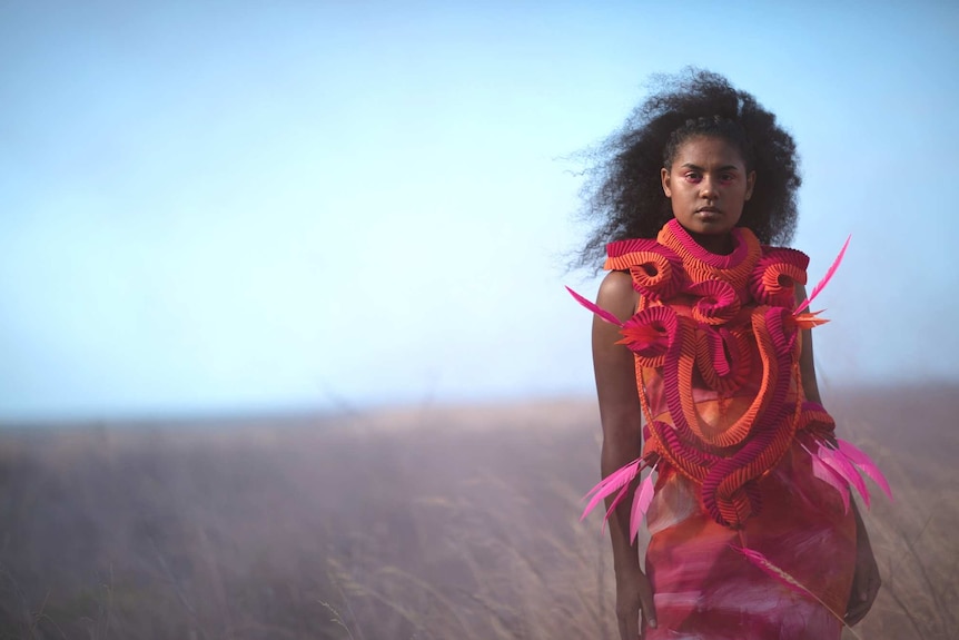 A young indigenous model wears a contemporary looking dress made using traditional indigenous weaving practices