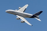 Airbus A380 flies through a clear blue sky.