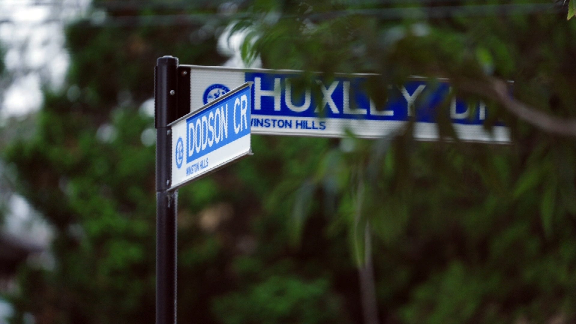 two street signs on a pole with one reading dodson cr andthe other huxley dr in winston hills
