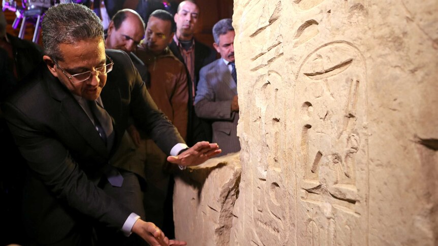 Egyptian Minister of Antiquities Khaled el-Anani stands beside the collosus showing the engravings