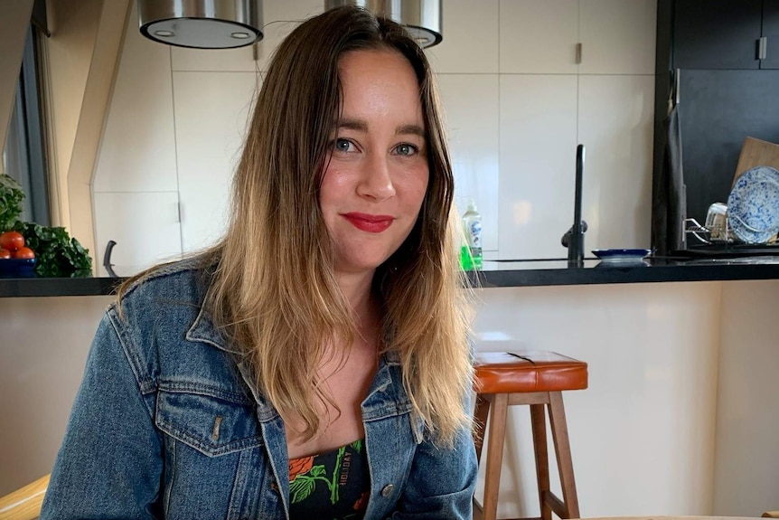 Alicia Twohill looks at a cookbook while sitting in front of her kitchen.