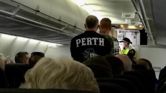 Two Rebels gang bikies are escorted off the plane.