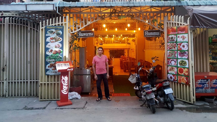Abdullah Zalghana stands outside his restaurant in Cambodia