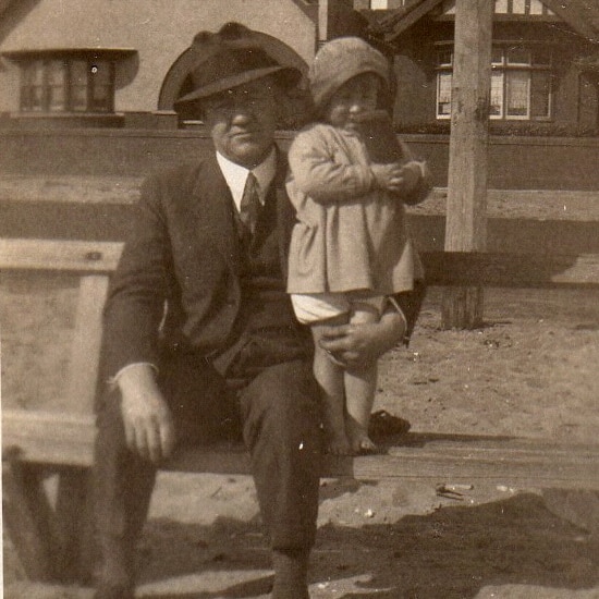 Sepia photo of man sitting on bench with little girl