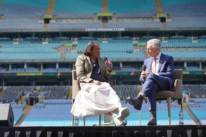 Cathy Freeman talks with Bruce McAvaney in front of a stand
