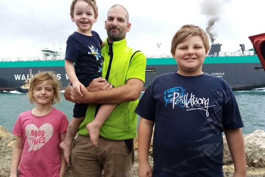 Kim Rowe and his three children pictured at a port