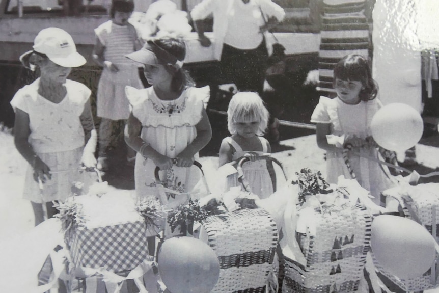 Black and white photo of children with toy prams.